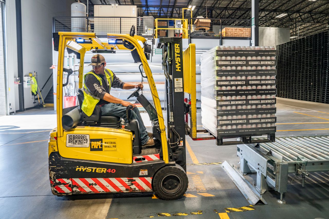 Staplerfahrer transportiert eine Palette im Lager